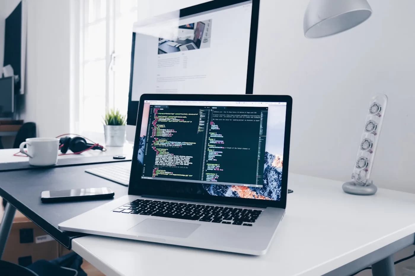 Admin console workspace with a desktop dashboard mockup and laptop
