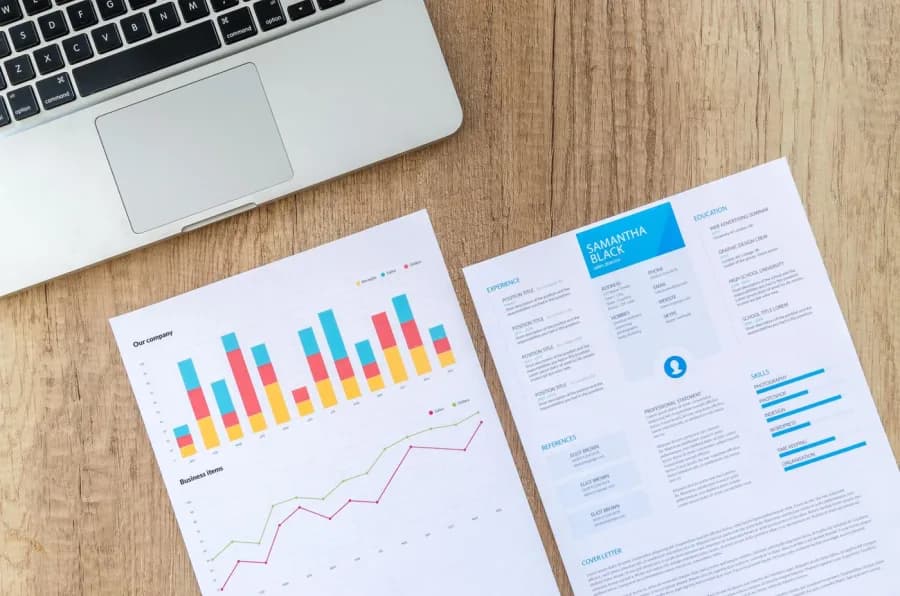 Printed sales and orders report next to a laptop keyboard